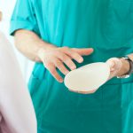 breast surgeon discusses implant options with patient