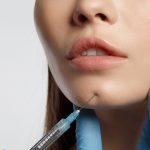 female patient getting a cosmetic injection to the chin