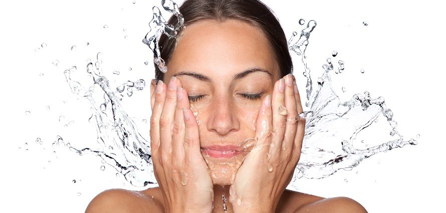 young female splashing water on her face