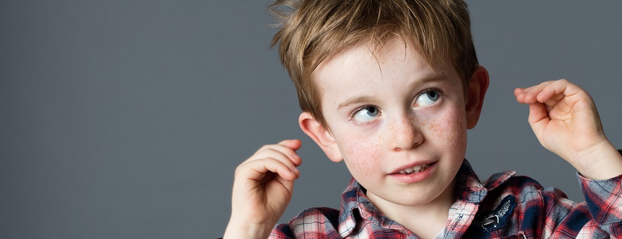 young boy reaching for his ears