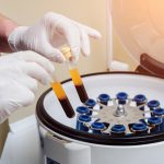 lab tech operating a blood centrifuge