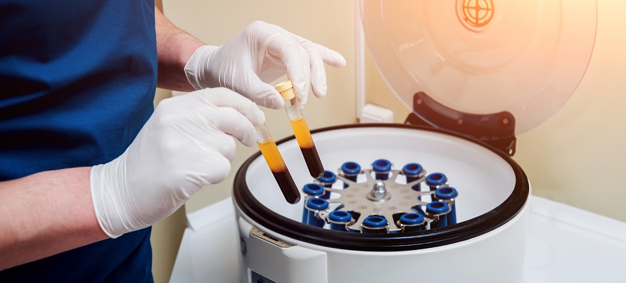 lab tech operating a blood centrifuge